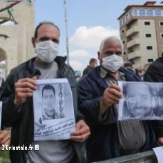 Palestiniens manifestant en portant des portraits d'hommes incarcrs en Isral