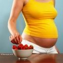 Femme enceinte choisissant une fraise