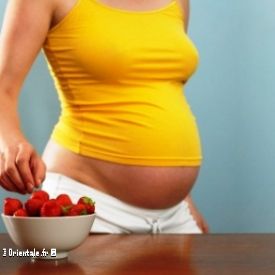 Femme enceinte choisissant une fraise