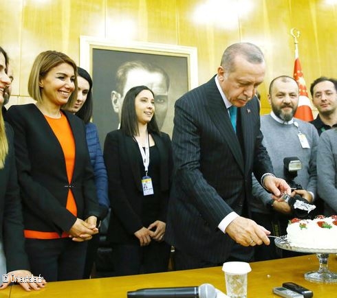 Le prsident turc Recep Tayyip Erdogan coupe un gteau offert par des journalistes  l'occasion de son 65e anniversaire peu de temps avant de partir pour une tourne africaine